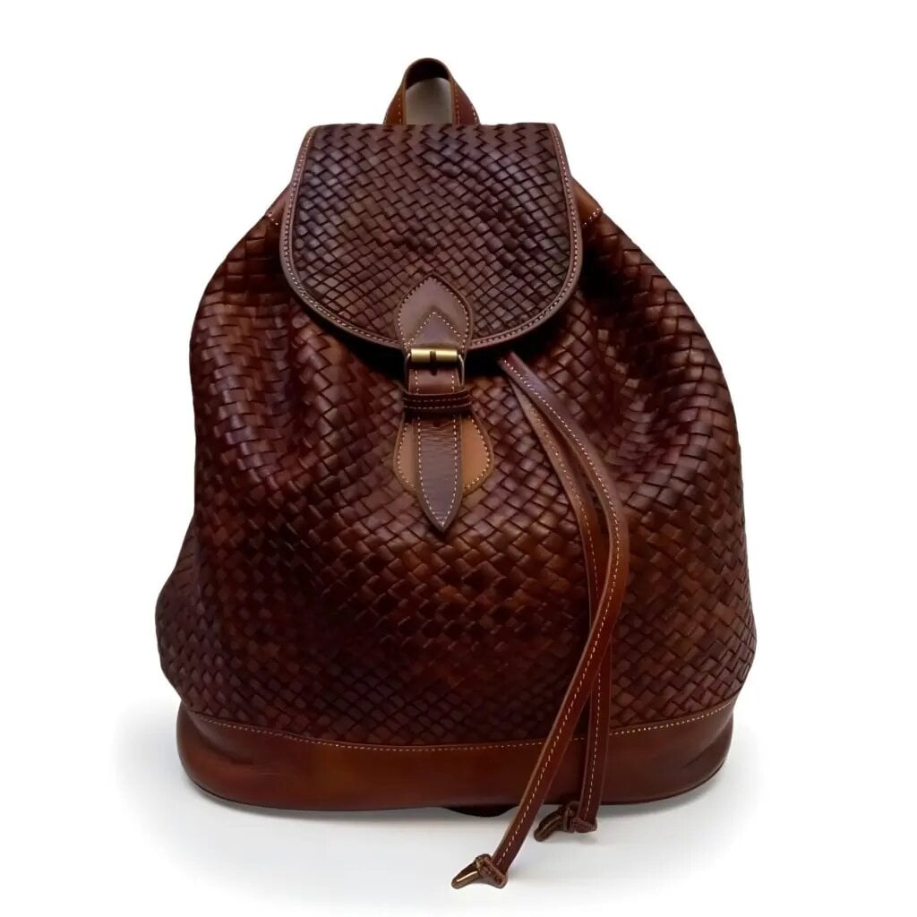 Brown woven leather backpack with basket-weave pattern and brass buckle on white background