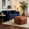 Braided leather square ottoman paired with navy velvet sofa in elegant living room