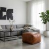 Cognac braided leather square ottoman in minimalist living room with grey sectional sofa