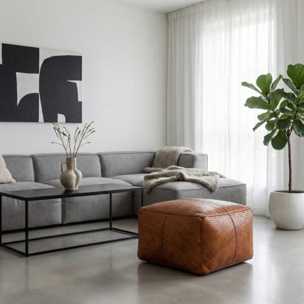 Cognac braided leather square ottoman in minimalist living room with grey sectional sofa