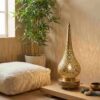 Brass filigree table lamp in zen meditation corner with floor cushion bamboo plant and singing bowl casting warm shadows Brass filigree table lamp in zen meditation corner with floor cushion bamboo plant and singing bowl casting warm shadows