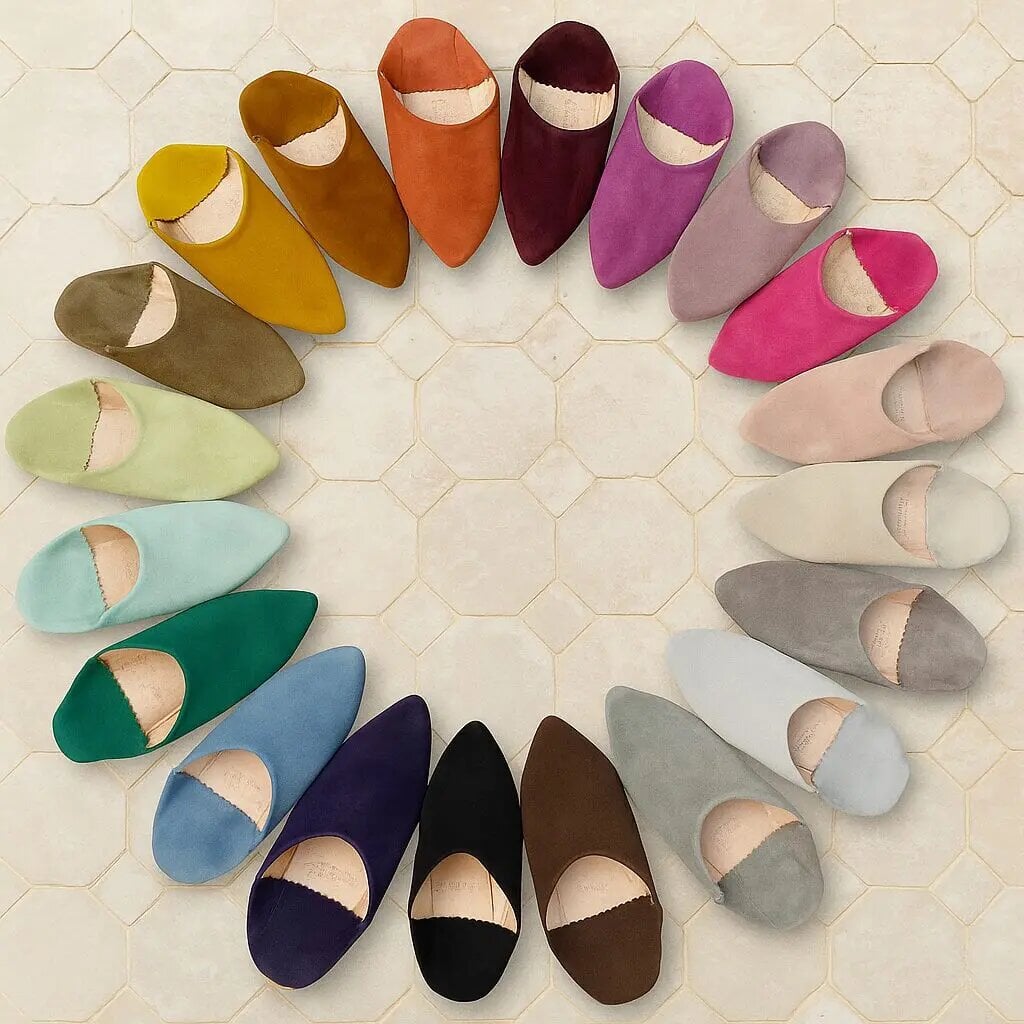 Handcrafted Moroccan slippers in 12 vibrant suede colors arranged in circle, showing pointed babouche design variety Handcrafted Moroccan slippers in 12 vibrant suede colors arranged in circle, showing pointed babouche design variety