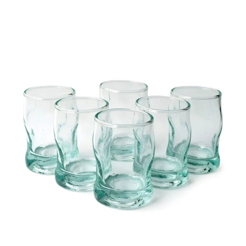 Six aqua-green hand-blown recycled glass tea glasses with wavy Beldi shape arranged on white background Six aqua-green hand-blown recycled glass tea glasses with wavy Beldi shape arranged on white background