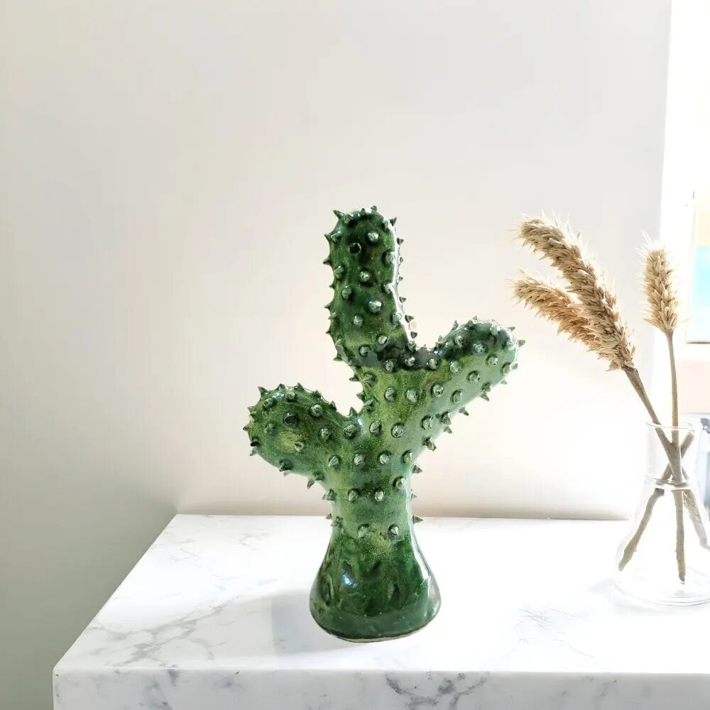 Handmade ceramic cactus sculpture with emerald green Tamegroute glaze and 3D spikes on marble table Handmade ceramic cactus sculpture with emerald green Tamegroute glaze and 3D spikes on marble table