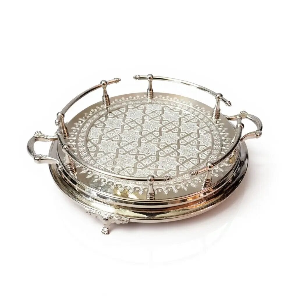Hand-engraved silver large round tray with geometric mandala pattern, decorative handles, and ball feet on white backgro Hand-engraved silver large round tray with geometric mandala pattern, decorative handles, and ball feet on white background.