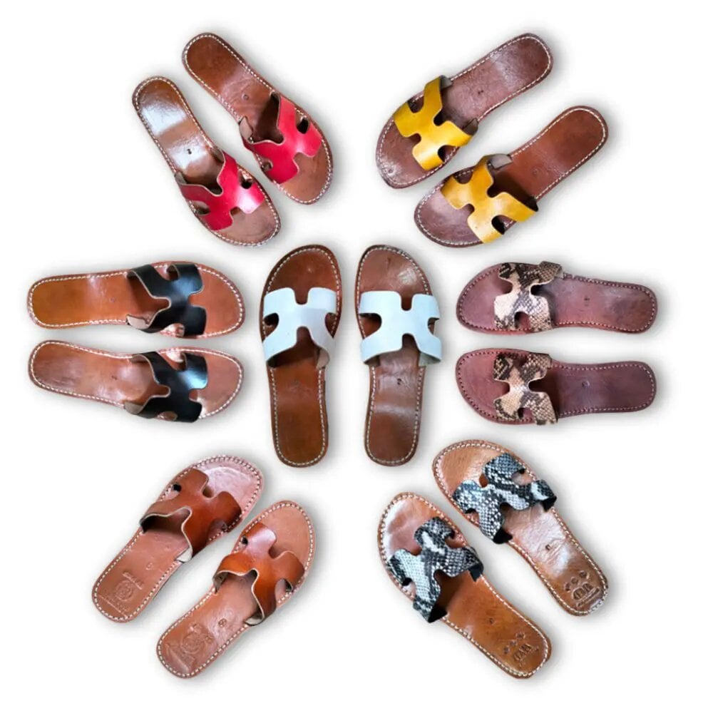 Handcrafted leather flat sandals collection with H-strap design in vibrant colors including pink, yellow, and snakeskin