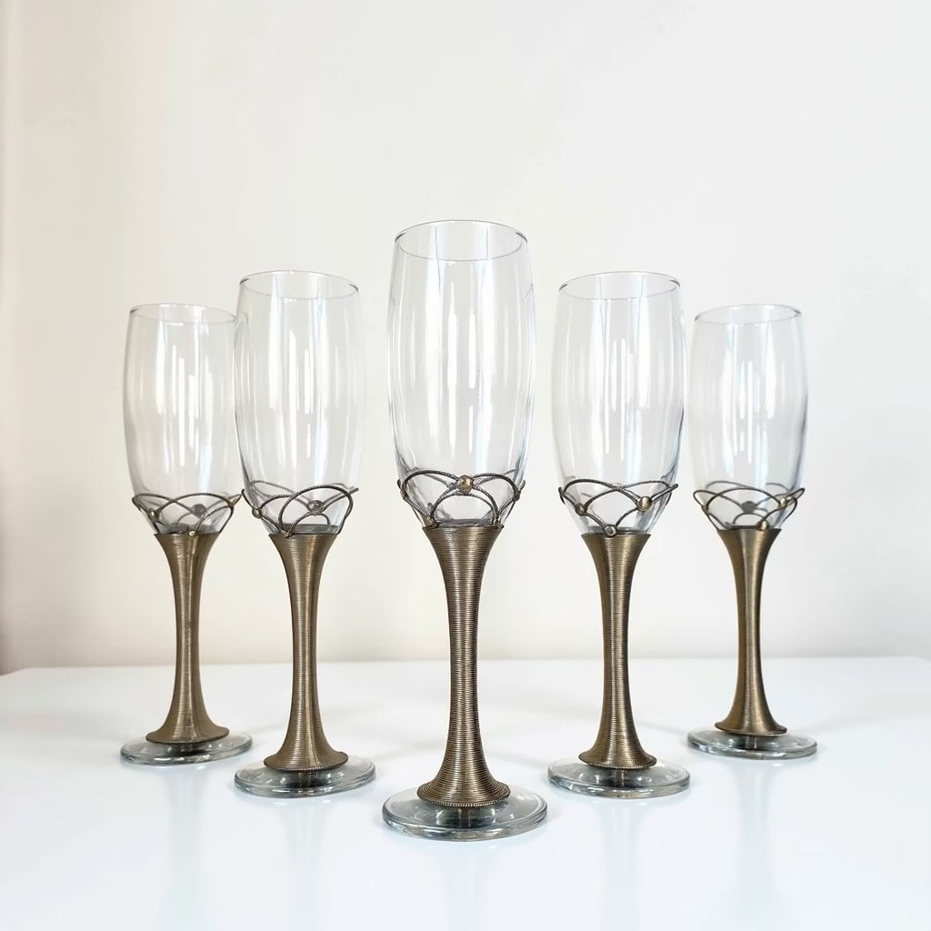 Set of filigree champagne flutes with silver wire-wrapped metal stems on white background Set of filigree champagne flutes with silver wire-wrapped metal stems on white background