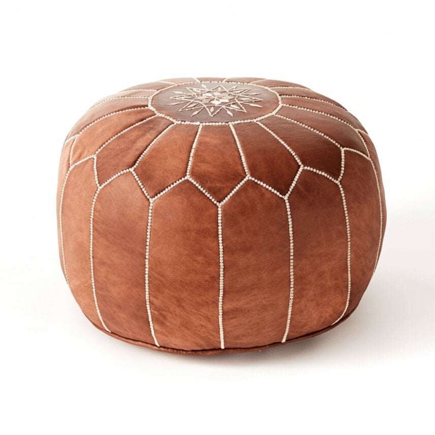 Tan leather floor ottoman with white embroidered star design, top-down studio view Tan leather floor ottoman with white embroidered star design, top-down studio view