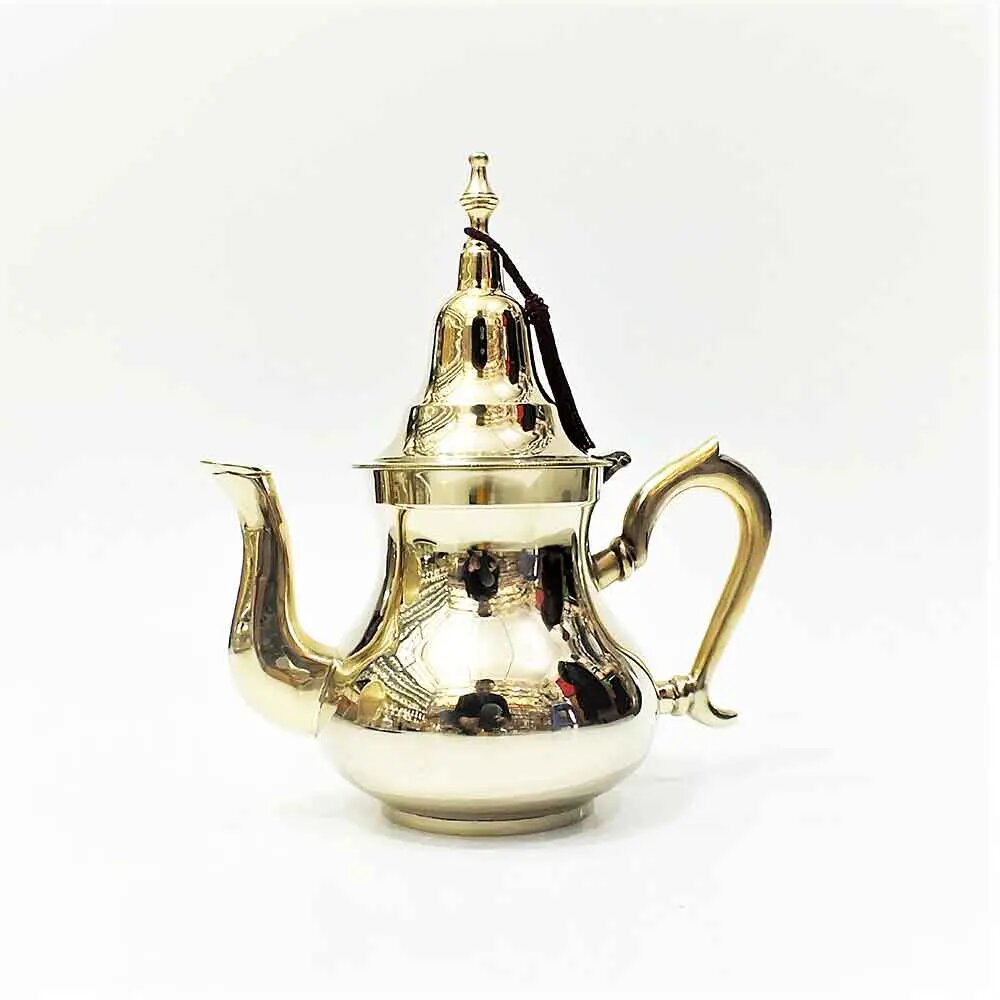 Mirror-polished brass teapot with curved spout, C-shaped handle, domed lid, and black silk tassel on white background.
