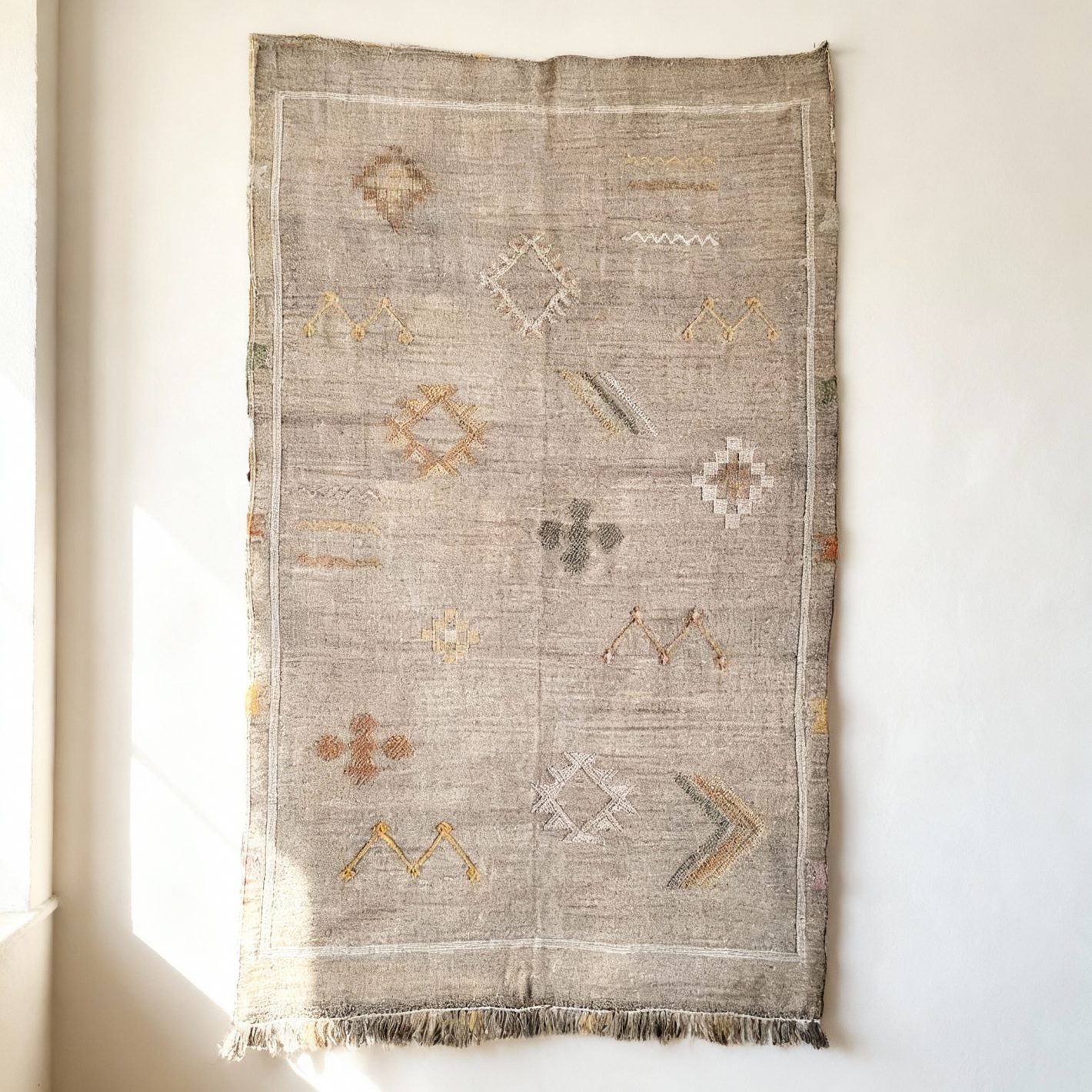 Gray handmade Moroccan cactus silk rug with geometric Berber patterns and fringe on white background Gray handmade Moroccan cactus silk rug with geometric Berber patterns and fringe on white background