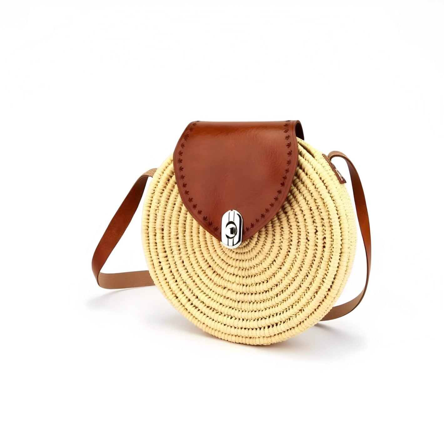 Round straw purse with cognac leather flap and silver clasp on white background