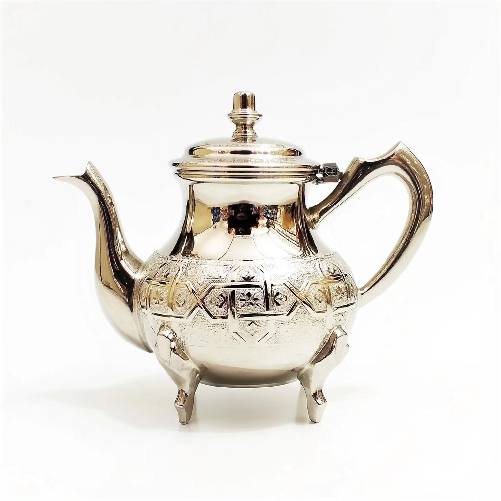 Silver-plated barrad teapot with hand-engraved geometric patterns, domed lid with clasp, and curved spout on white