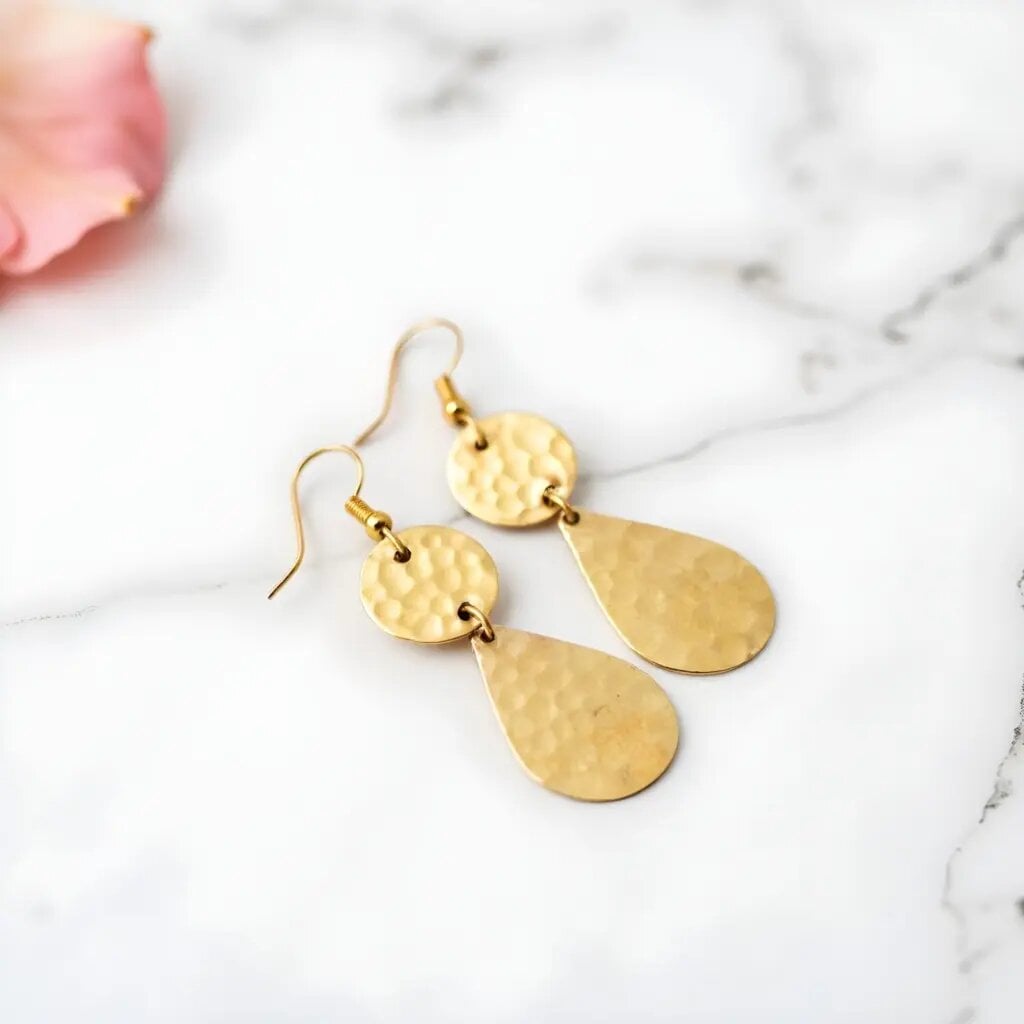 Hammered brass earrings with gold teardrop design on white marble, showing textured finish and two-tier style Hammered brass earrings with gold teardrop design on white marble, showing textured finish and two-tier style