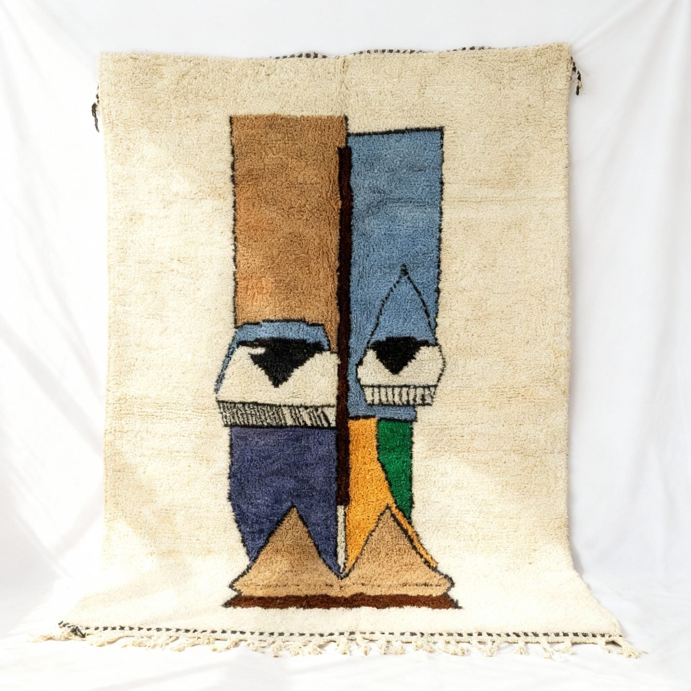 Abstract face Berber wool rug in cream with blue and gold accents, handwoven with tribal motif displayed flat