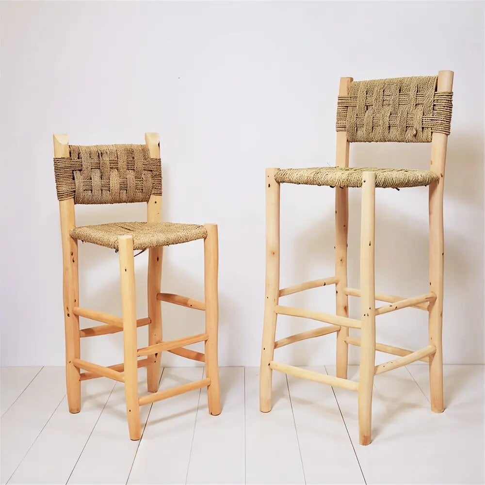 Handwoven bar chairs with natural palm leaf seats and lemon wood frames in two heights on white floor Handwoven bar chairs with natural palm leaf seats and lemon wood frames in two heights on white floor