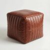 Light brown channel stitched leather cube ottoman pouf on white studio background Light brown channel stitched leather cube ottoman pouf on white studio background