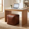 Channel stitched leather cube ottoman used as desk seating in a modern home office with natural wood furniture Channel stitched leather cube ottoman used as desk seating in a modern home office with natural wood furniture