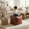 Child sitting on a channel stitched leather cube ottoman while reading in a cozy neutral living room Child sitting on a channel stitched leather cube ottoman while reading in a cozy neutral living room