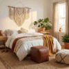 Channel stitched leather cube ottoman placed at the foot of a bed in a bohemian bedroom with neutral decor Channel stitched leather cube ottoman placed at the foot of a bed in a bohemian bedroom with neutral decor