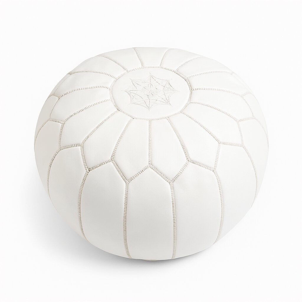 White leather round ottoman with hand-embroidered eight-pointed star and geometric panel stitching on plain background White leather round ottoman with hand-embroidered eight-pointed star and geometric panel stitching on plain background