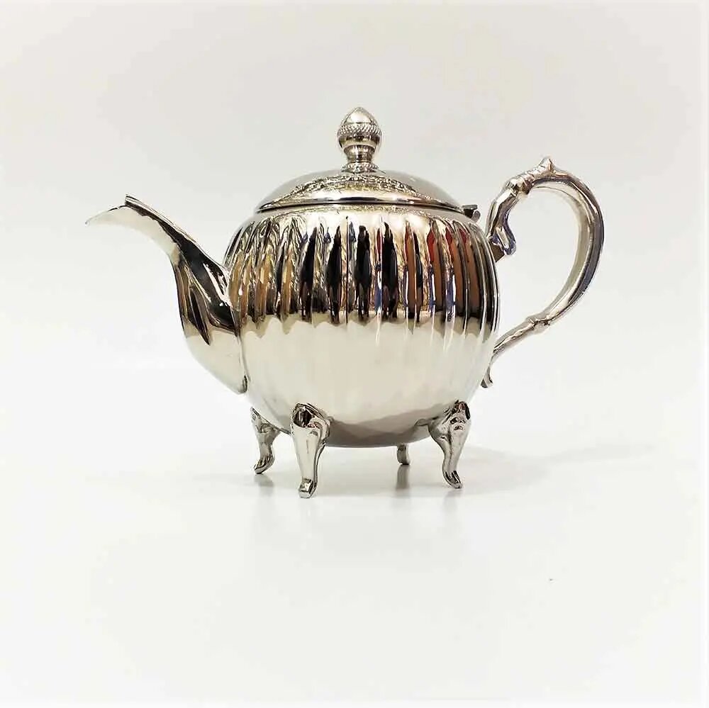 Deep fluted silver teapot with scroll cabriole feet and pierced arabesque detail on white background Deep fluted silver teapot with scroll cabriole feet and pierced arabesque detail on white background