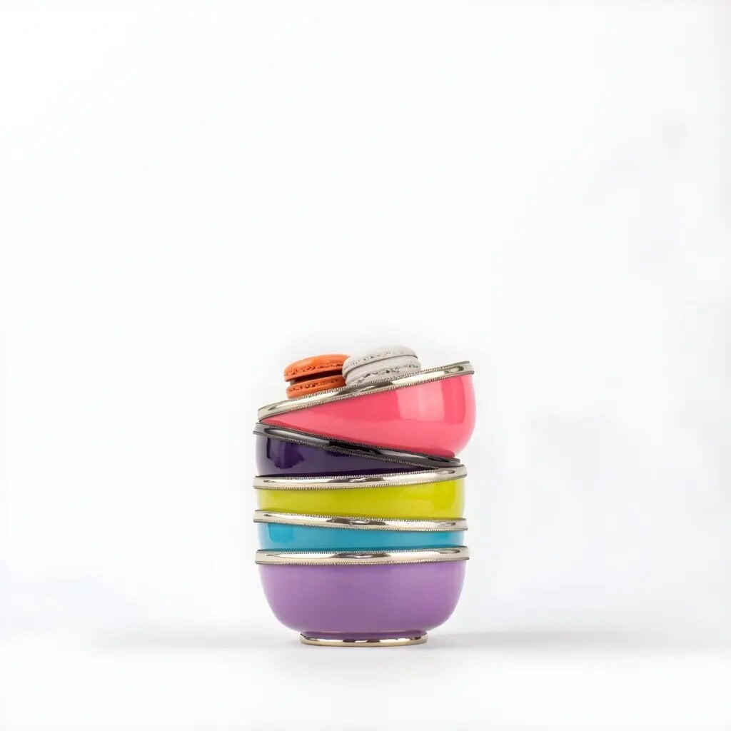 Ceramic bowls with silver trim stacked vertically with macarons on top, showing vibrant colors and metallic edges Ceramic bowls with silver trim stacked vertically with macarons on top, showing vibrant colors and metallic edges