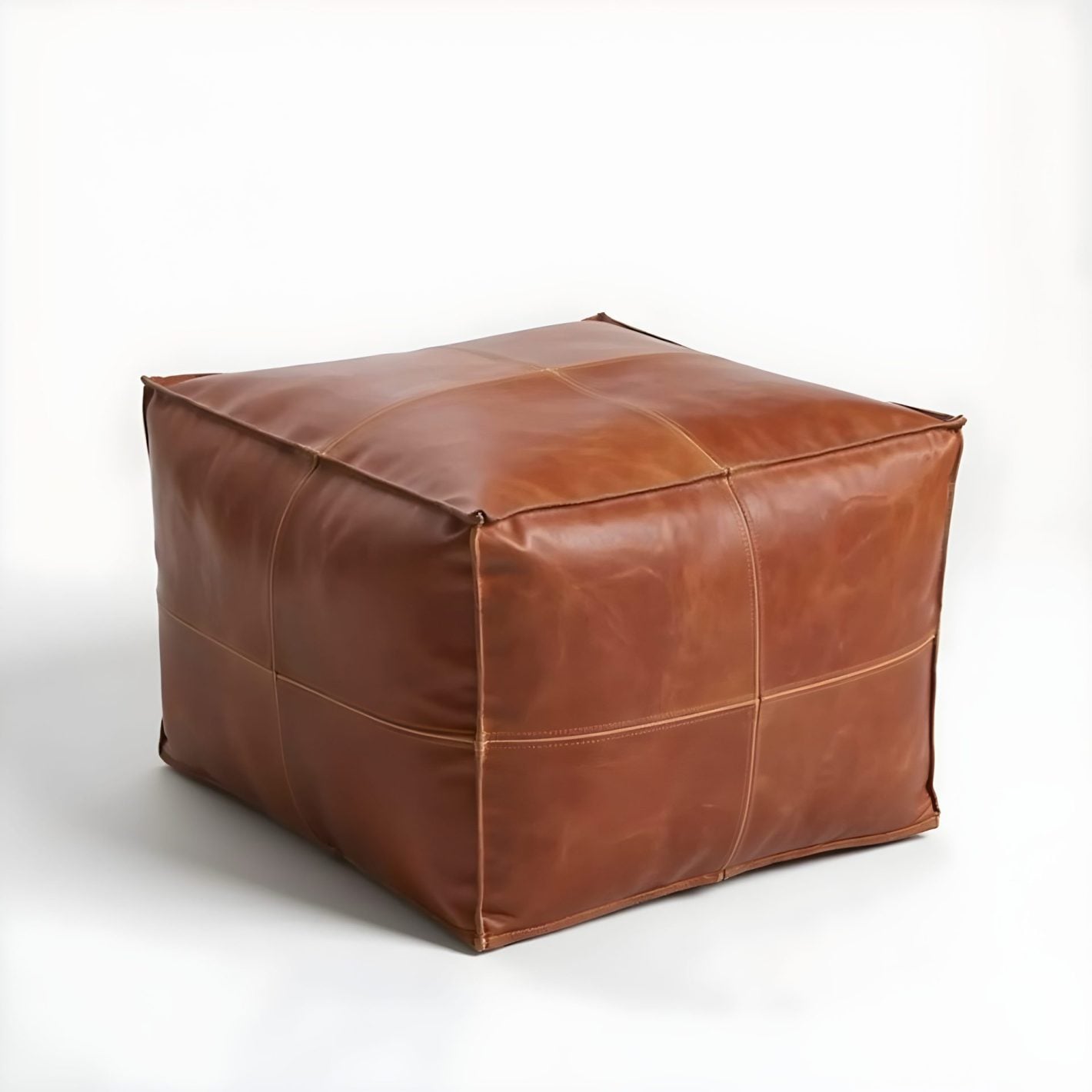 Brown square leather ottoman with cross-stitch geometric patchwork detail on white background Brown square leather ottoman with cross-stitch geometric patchwork detail on white background