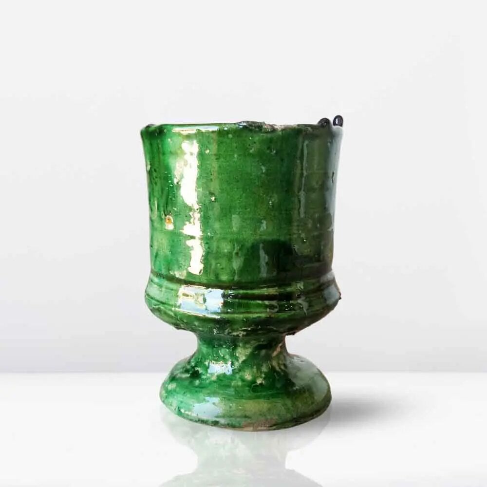 Handcrafted Tamegroute pottery mug with emerald green glaze and footed base on white background