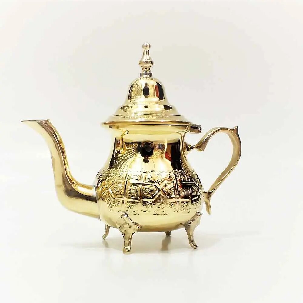 Hand engraved brass teapot in natural gold tone with arabesque geometric patterns, domed lid, curved spout, and three sm Hand engraved brass teapot in natural gold tone with arabesque geometric patterns, domed lid, curved spout, and three small feet on white background
