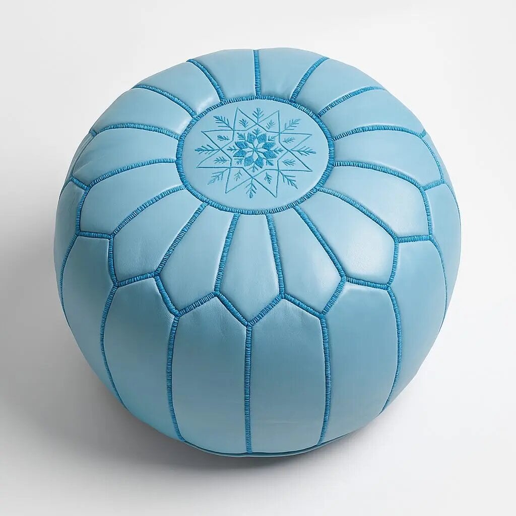 Sky blue leather round pouf with hand-embroidered geometric star design, overhead view on plain background Sky blue leather round pouf with hand-embroidered geometric star design, overhead view on plain background