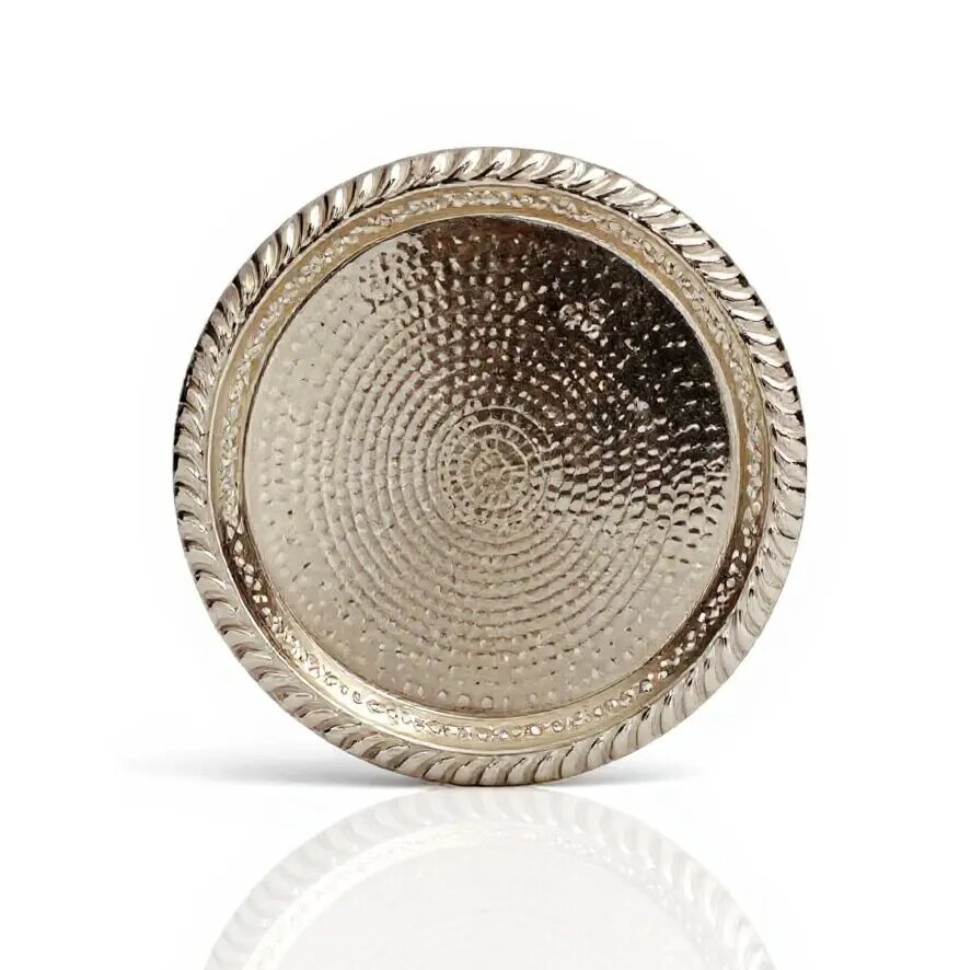 Overhead view of hand hammered silver circle tray with concentric dimple texture and twisted rope border Overhead view of hand hammered silver circle tray with concentric dimple texture and twisted rope border