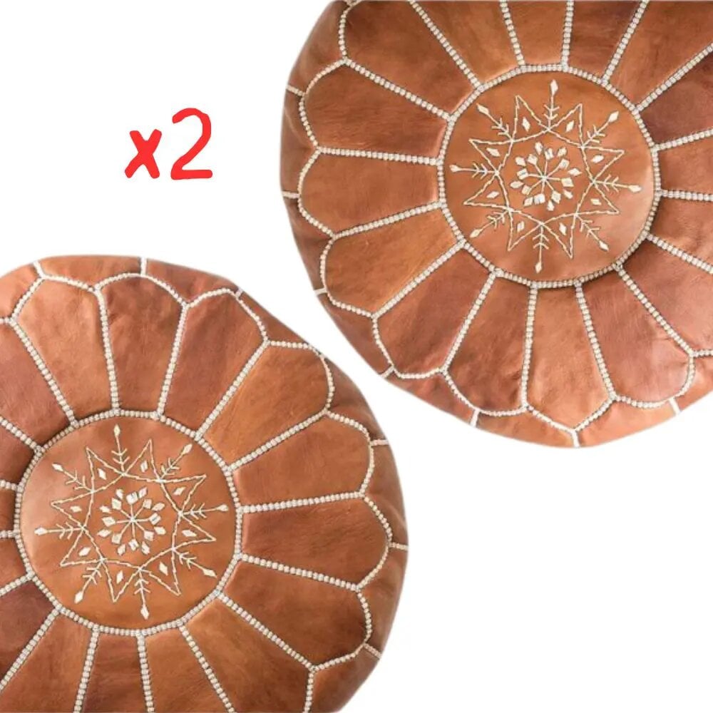Two tan leather round ottomans with white embroidered geometric star design, top view on white background Two tan leather round ottomans with white embroidered geometric star design, top view on white background