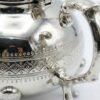 Close-up of hand-engraved interlocking diamond lattice pattern on silver teapot body