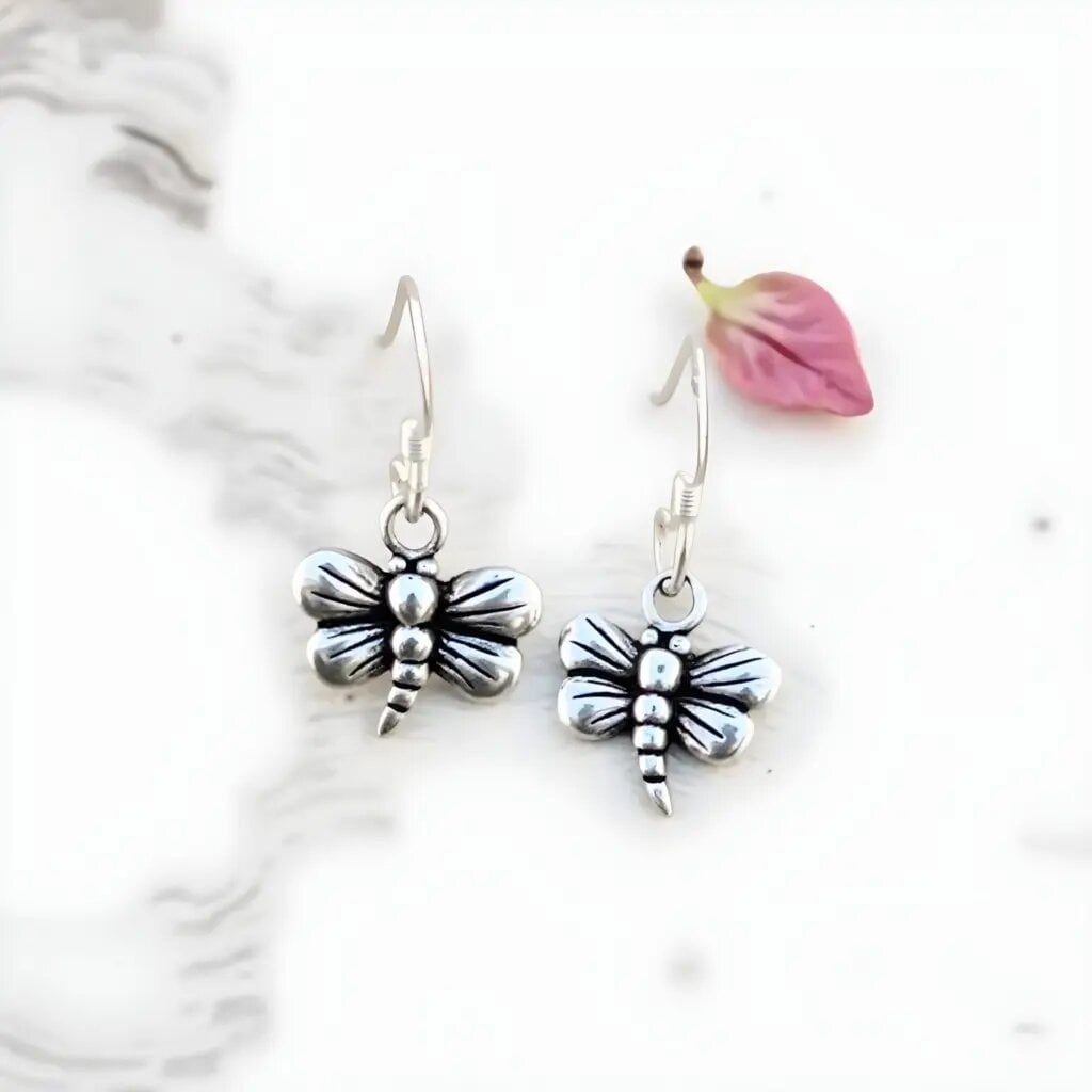Sterling silver dragonfly earrings with antiqued finish on white background, handcrafted drop design