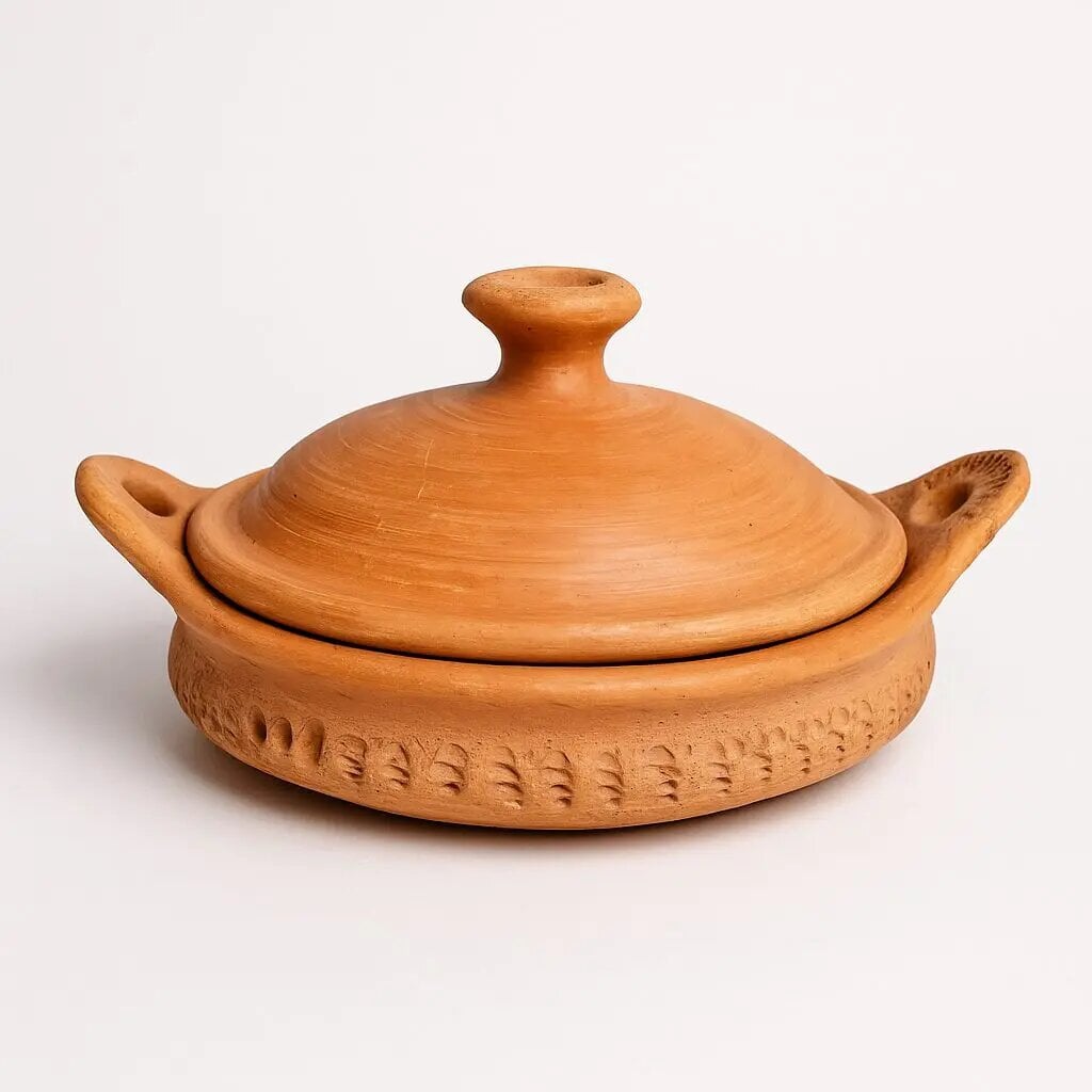 Handmade terracotta tagine pottery with conical lid and carved geometric patterns from Marrakech artisan workshop Handmade terracotta tagine pottery with conical lid and carved geometric patterns from Marrakech artisan workshop