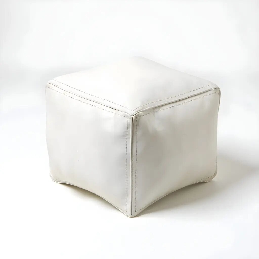 White square leather pouf with contrast stitching and natural grain on white background White square leather pouf with contrast stitching and natural grain on white background