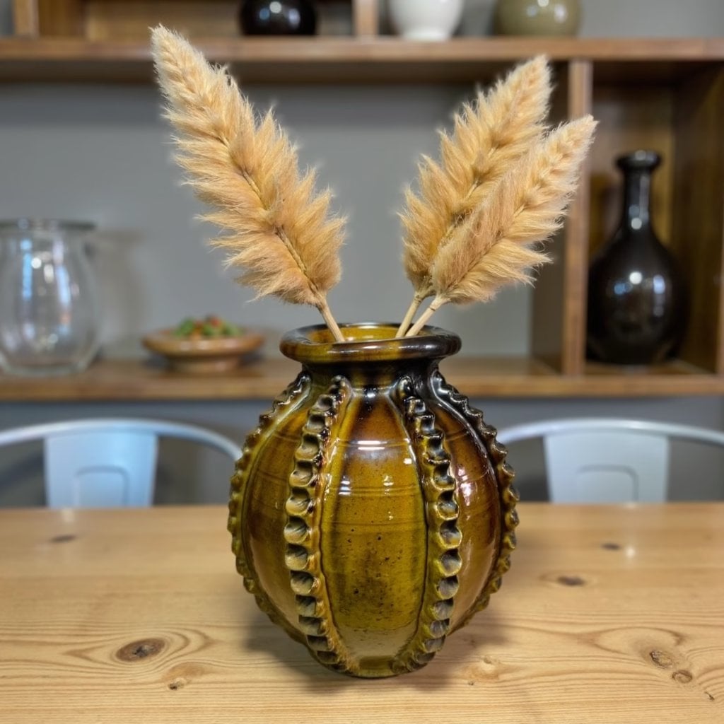 Handmade ceramic vase 30cm with raised patterns in amber brown glaze holding dried pampas grass on wooden table Handmade ceramic vase 30cm with raised patterns in amber brown glaze holding dried pampas grass on wooden table
