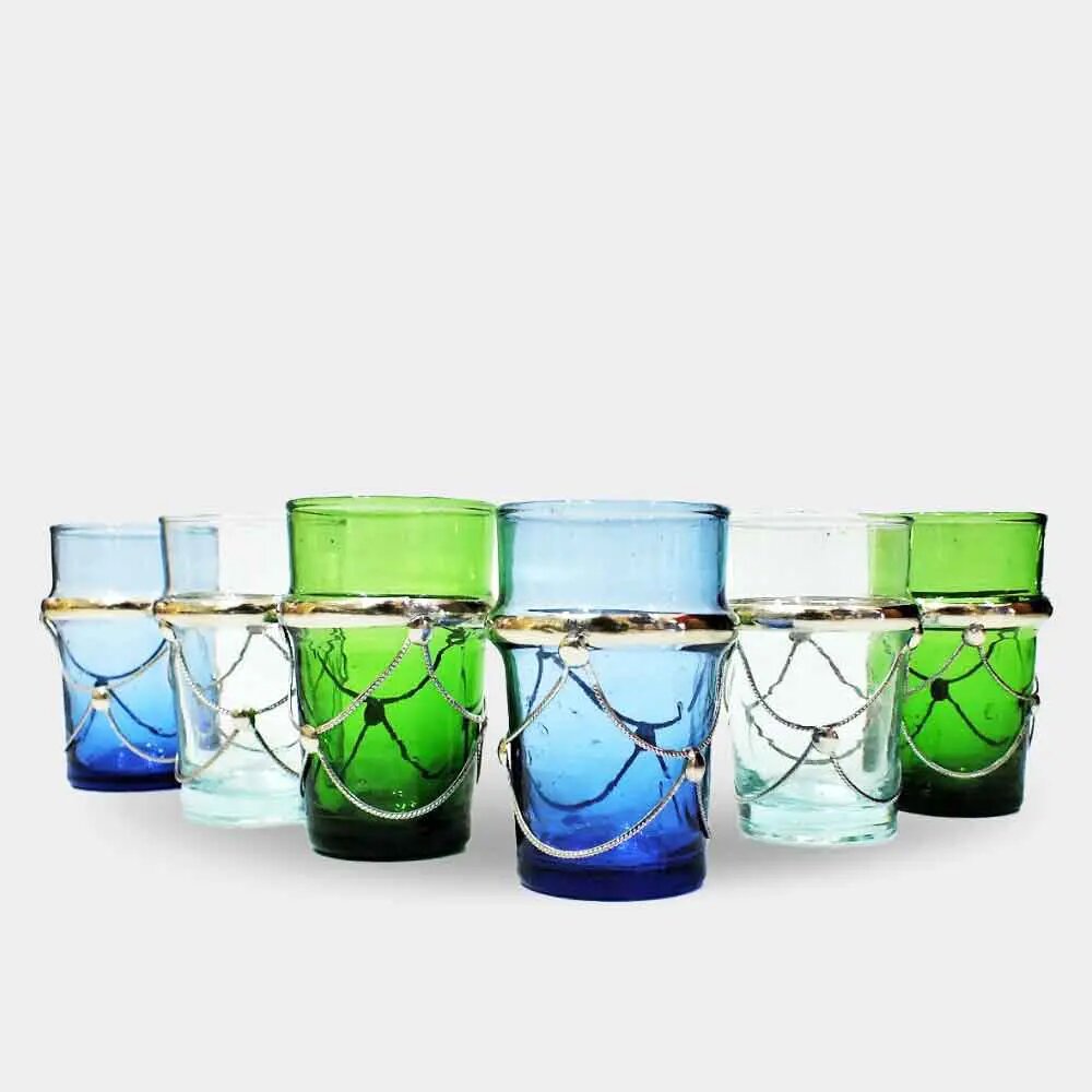 Set of six filigree tea glasses with metal holders in blue, green, and clear on white background Set of six filigree tea glasses with metal holders in blue, green, and clear on white background
