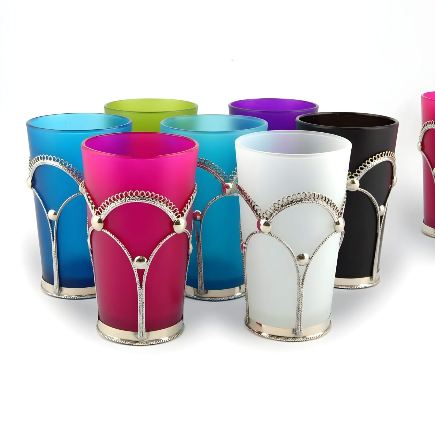 Six jewel-tone Moroccan tea glasses in silver filigree holders arranged on white background Six jewel-tone Moroccan tea glasses in silver filigree holders arranged on white background