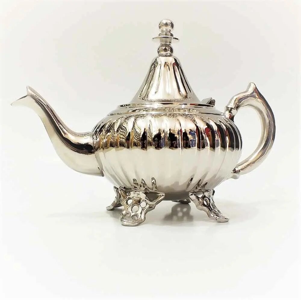 Full height ribbed silver teapot with tall pointed dome lid, curved spout, ornate handle, and four pierced scroll feet o Full height ribbed silver teapot with tall pointed dome lid, curved spout, ornate handle, and four pierced scroll feet on white background