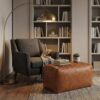 Light brown woven leather bench ottoman as side table beside grey armchair in reading nook Light brown woven leather bench ottoman as side table beside grey armchair in reading nook