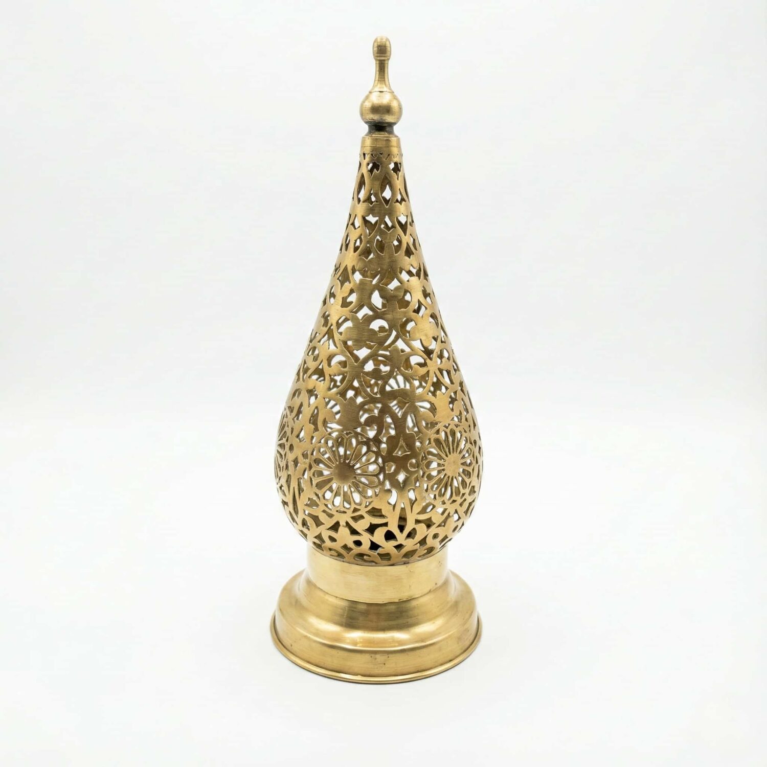 Isolated product view of a handcrafted Moroccan brass bedside lamp featuring a teardrop shape and detailed metal cutouts Isolated product view of a handcrafted Moroccan brass bedside lamp featuring a teardrop shape and detailed metal cutouts on a white background.