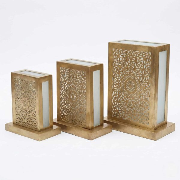 Three brass lantern table lamps in small medium and large sizes with hand-pierced front panels and frosted glass sides Three brass lantern table lamps in small medium and large sizes with hand-pierced front panels and frosted glass sides