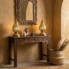 Pair of brass pear table lamps flanking ornate mirror on carved wooden console table in bohemian entryway Pair of brass pear table lamps flanking ornate mirror on carved wooden console table in bohemian entryway