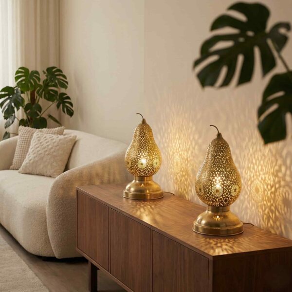 Brass pear table lamps on modern credenza in minimalist living room projecting intricate light patterns Brass pear table lamps on modern credenza in minimalist living room projecting intricate light patterns