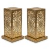 Pair of hand-engraved perforated brass table lamps with geometric floral patterns glowing warmly against white backgroun Pair of hand-engraved perforated brass table lamps with geometric floral patterns glowing warmly against white background