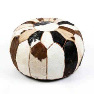Round cowhide pouf with brown black and white hair-on-hide patchwork panels on white background