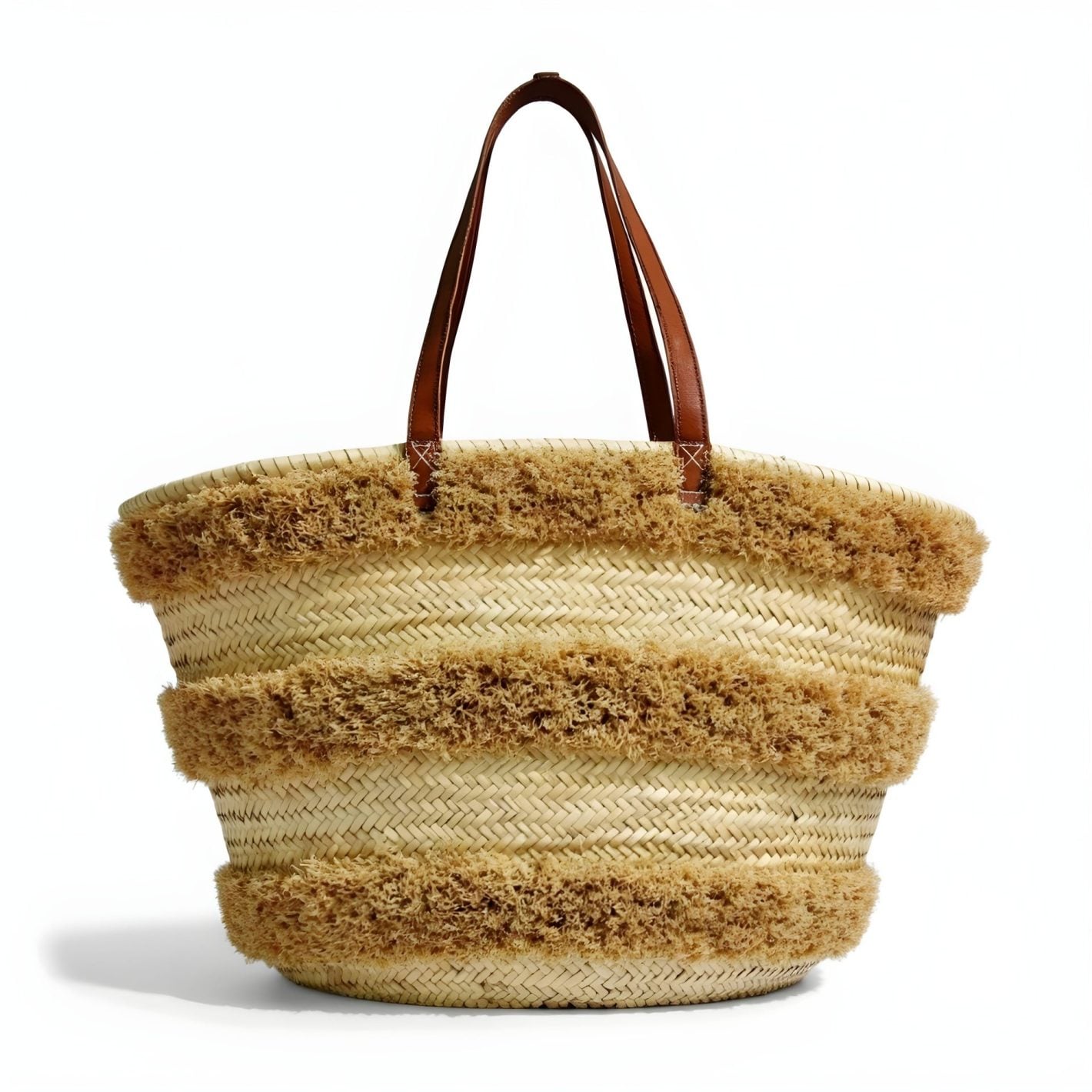 Close-up of woven straw texture and fuzzy fringe detail on striped bag.
