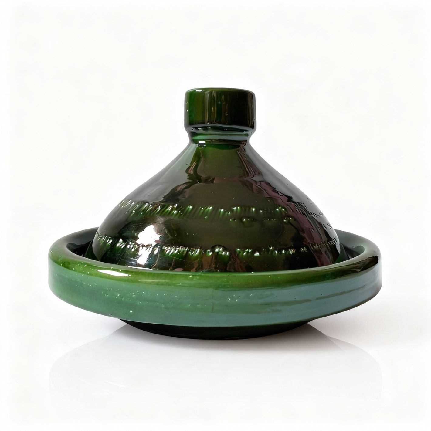 Green ceramic tagine pot with conical lid and flat base, handcrafted Moroccan cookware on white background Green ceramic tagine pot with conical lid and flat base, handcrafted Moroccan cookware on white background