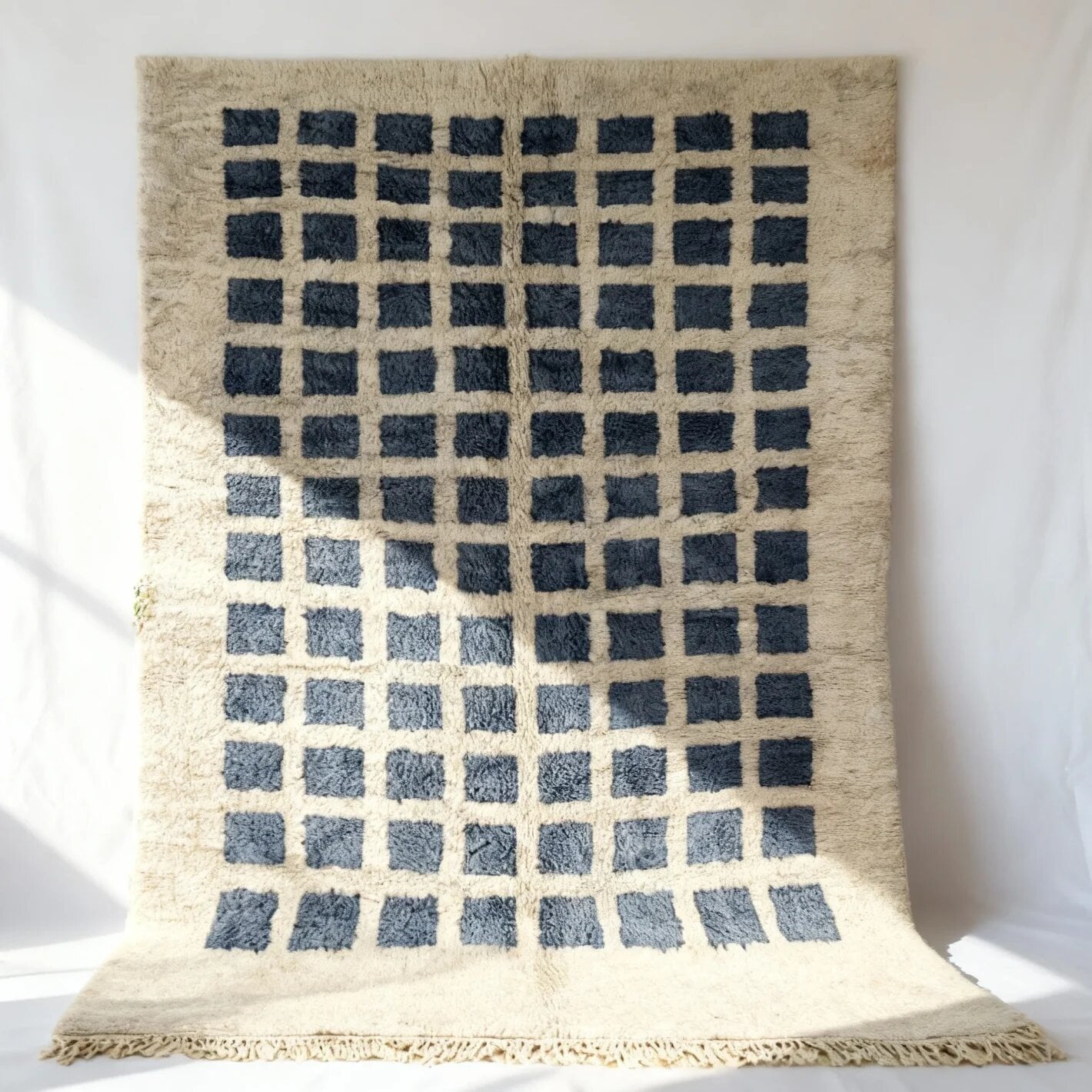 Ombré blue gray geometric wool rug with checkered Berber grid on cream base and traditional fringe detail